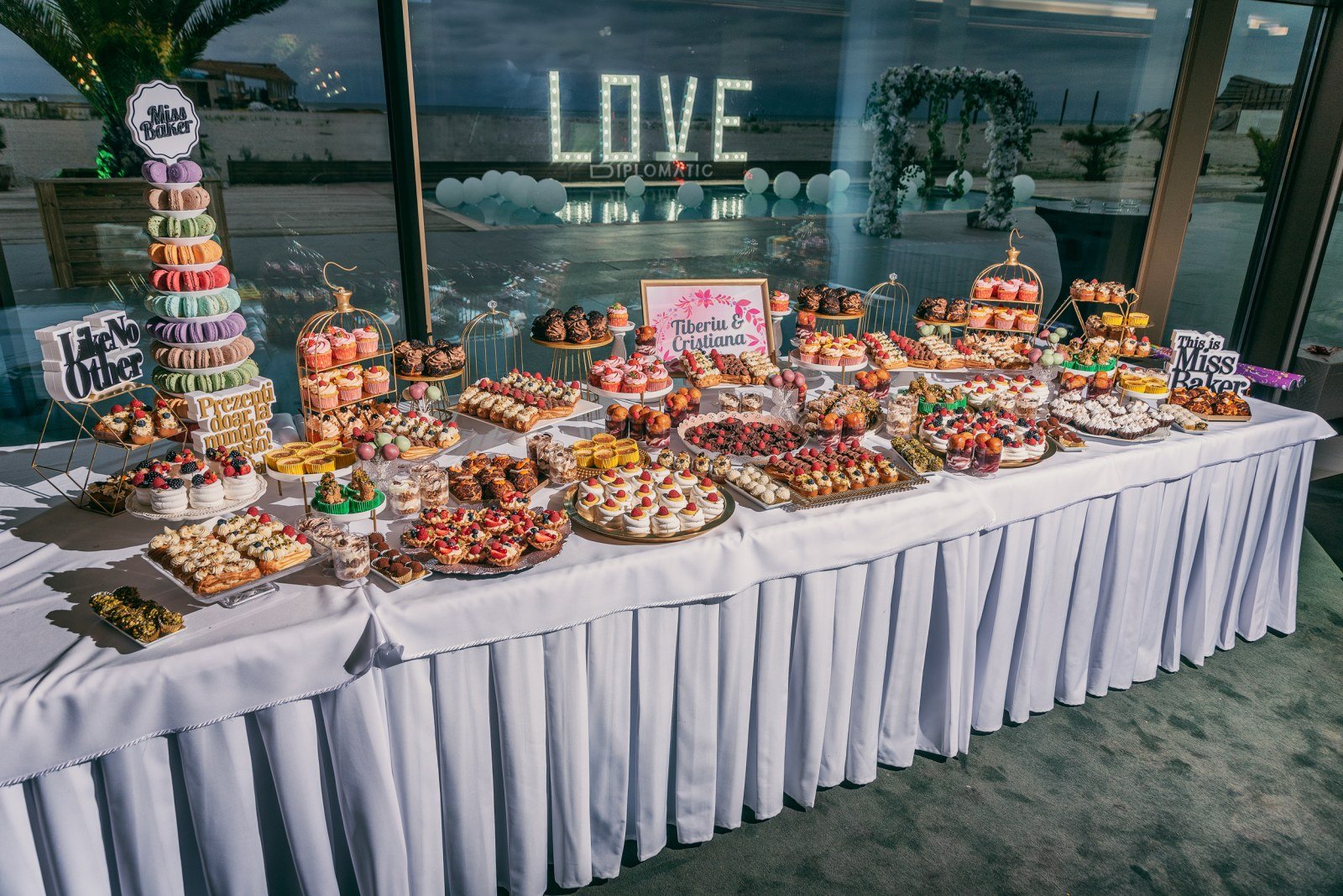 Candy Bar pentru nuntă — turn macarons multicolor, platou etajat sticlă, aranjament prăjituri simetric — Miss Baker Constanța