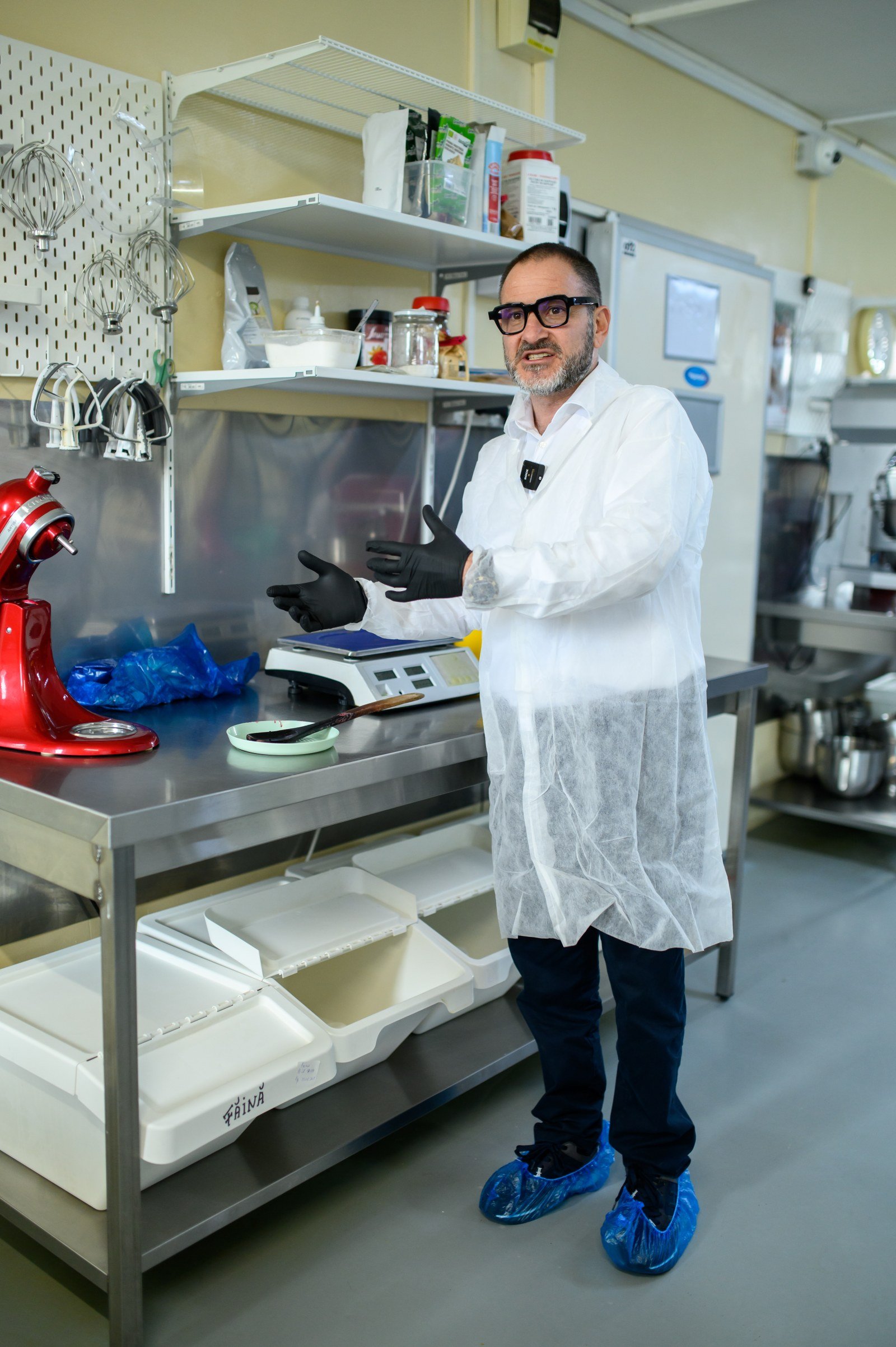 Laboratorul din Cumpăna — masă inox profesională, malaxor roșu lucios, raft metalic suspendat — Miss Baker Constanța