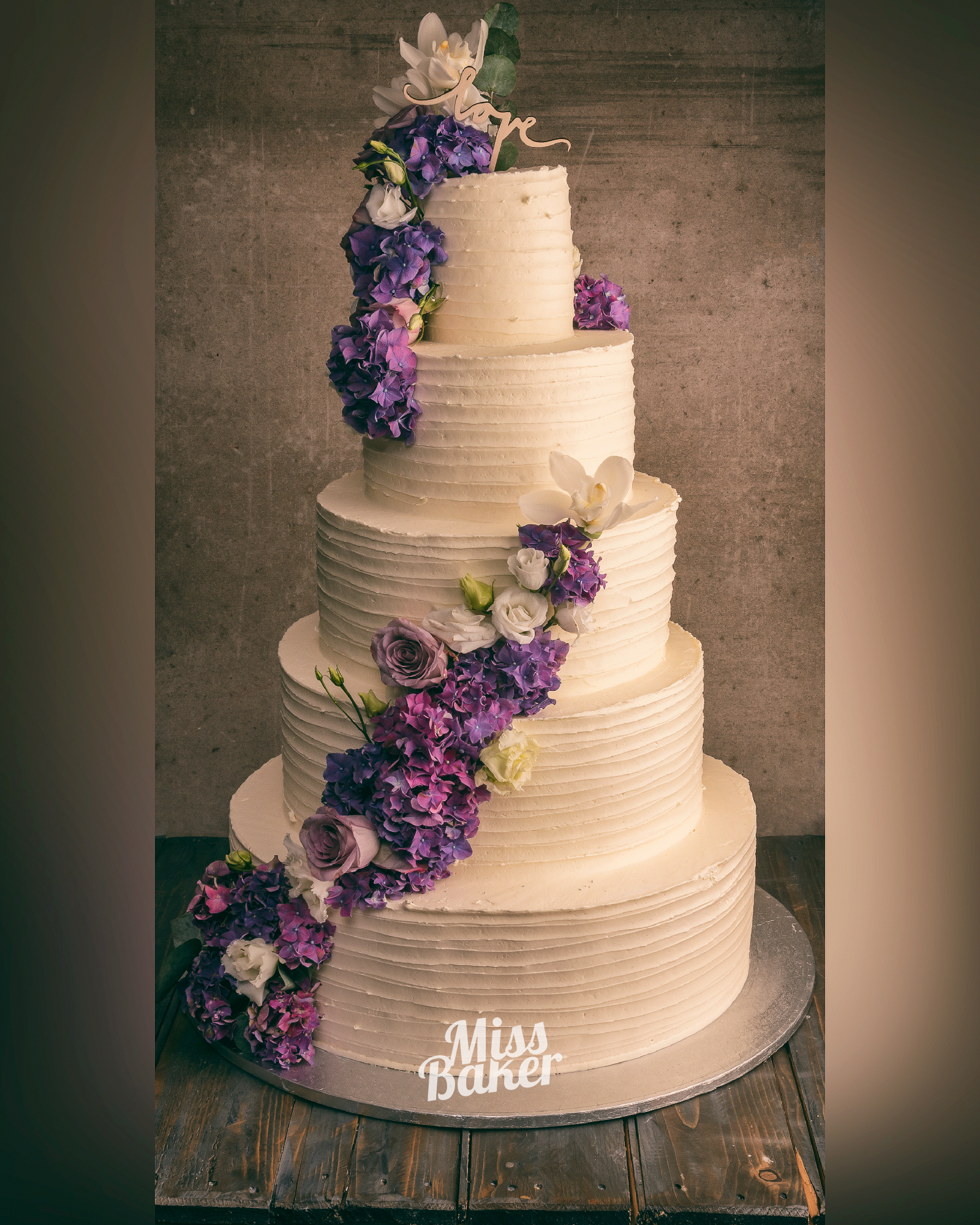 Torturi de nuntă de la Miss Baker — patru niveluri, aranjament floral diagonal, bază rotundă