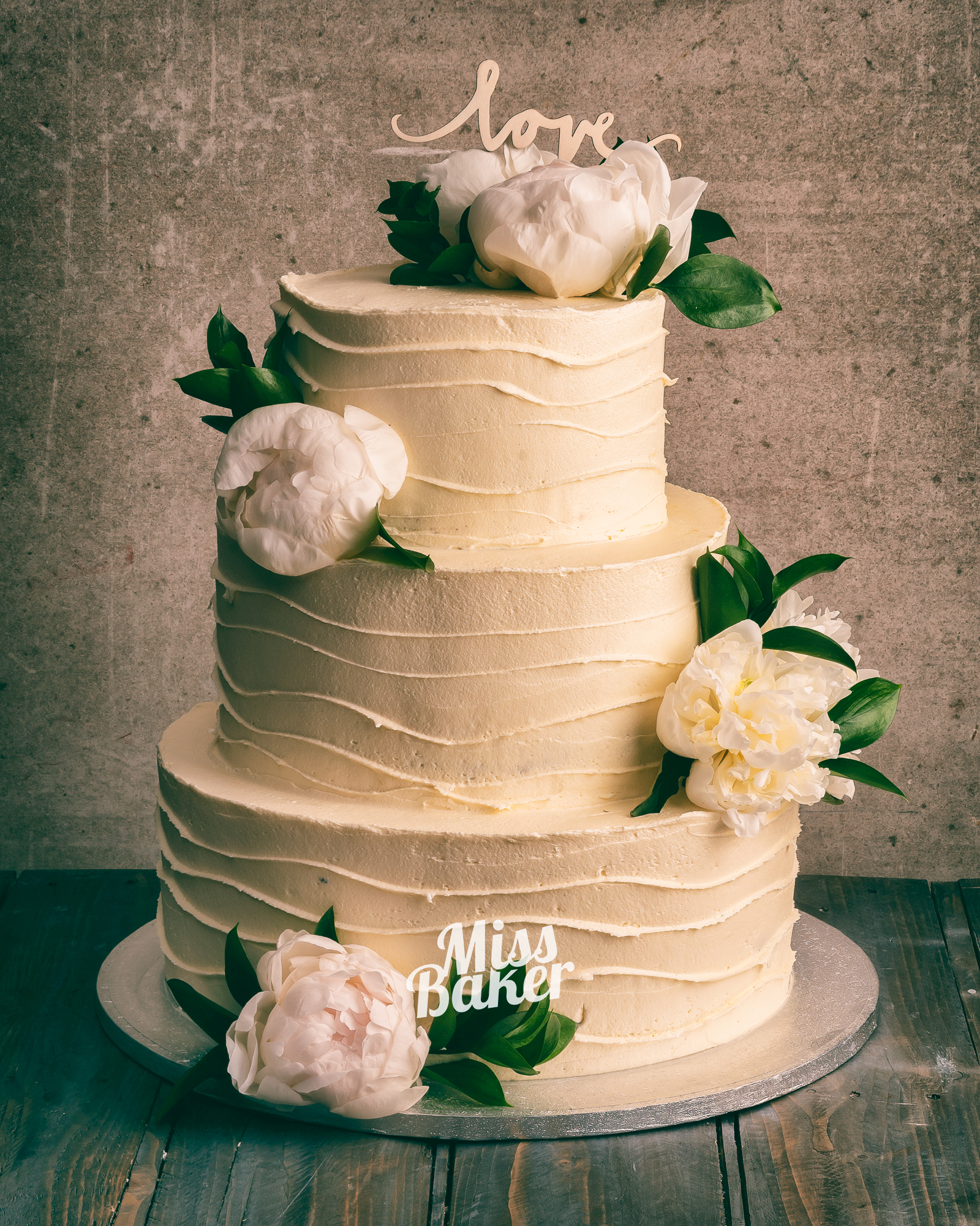 Torturi de nuntă de la Miss Baker — trei niveluri, flori naturale albe, frunze verzi