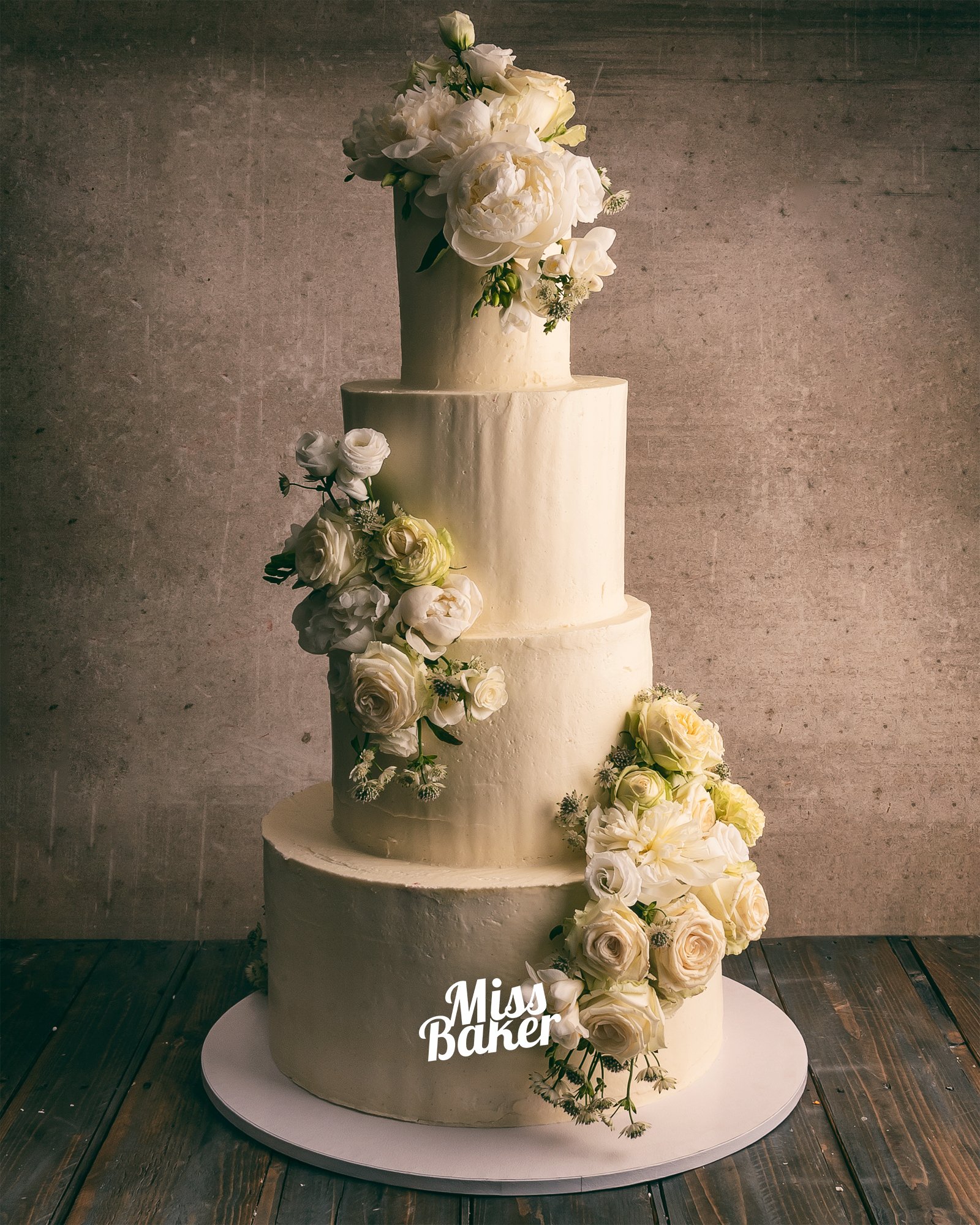 Torturi de nuntă de la Miss Baker — patru niveluri, aranjament floral diagonal, flori naturale ivoire