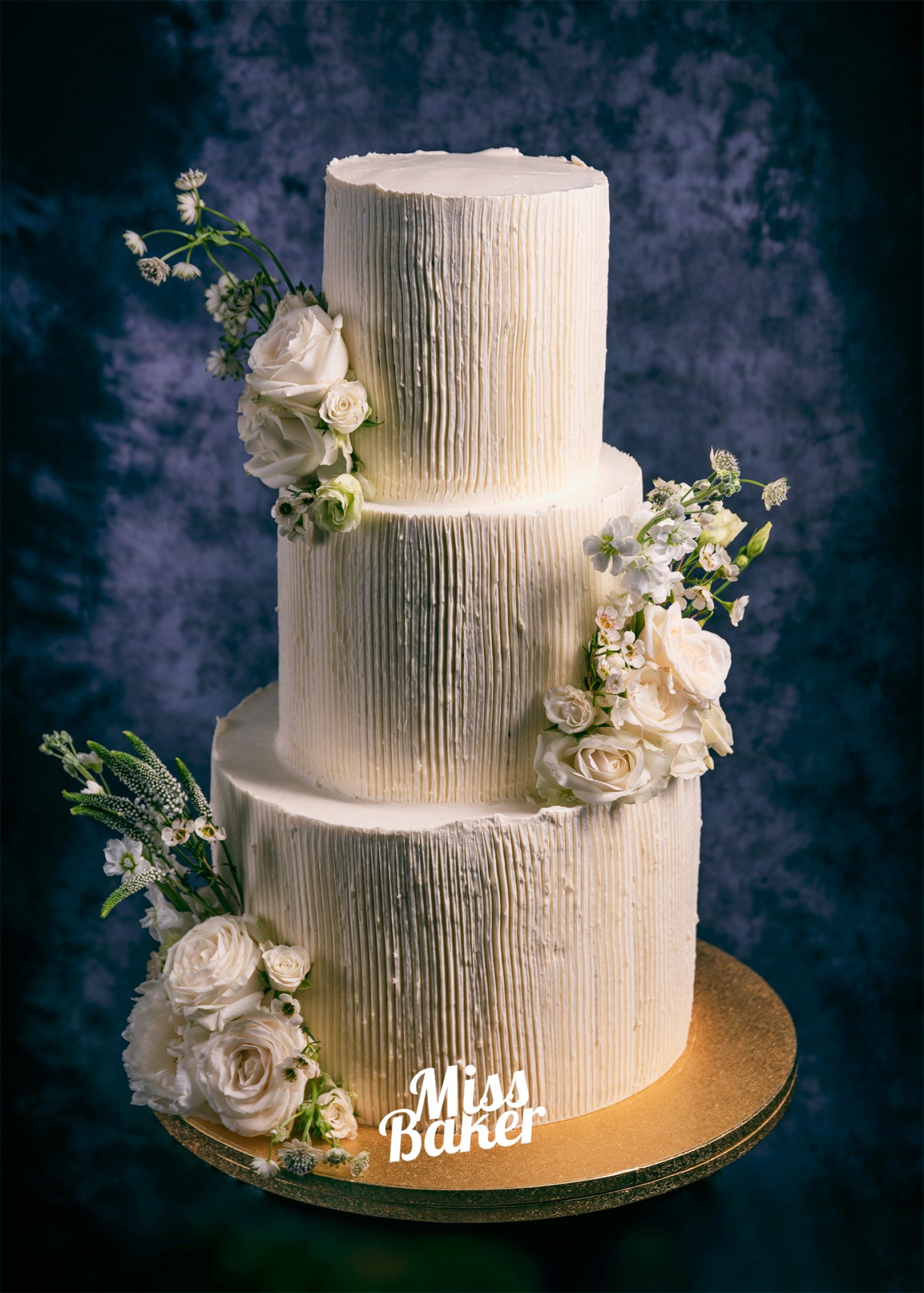 Torturi de nuntă de la Miss Baker — trei niveluri, textură verticală, flori naturale albe