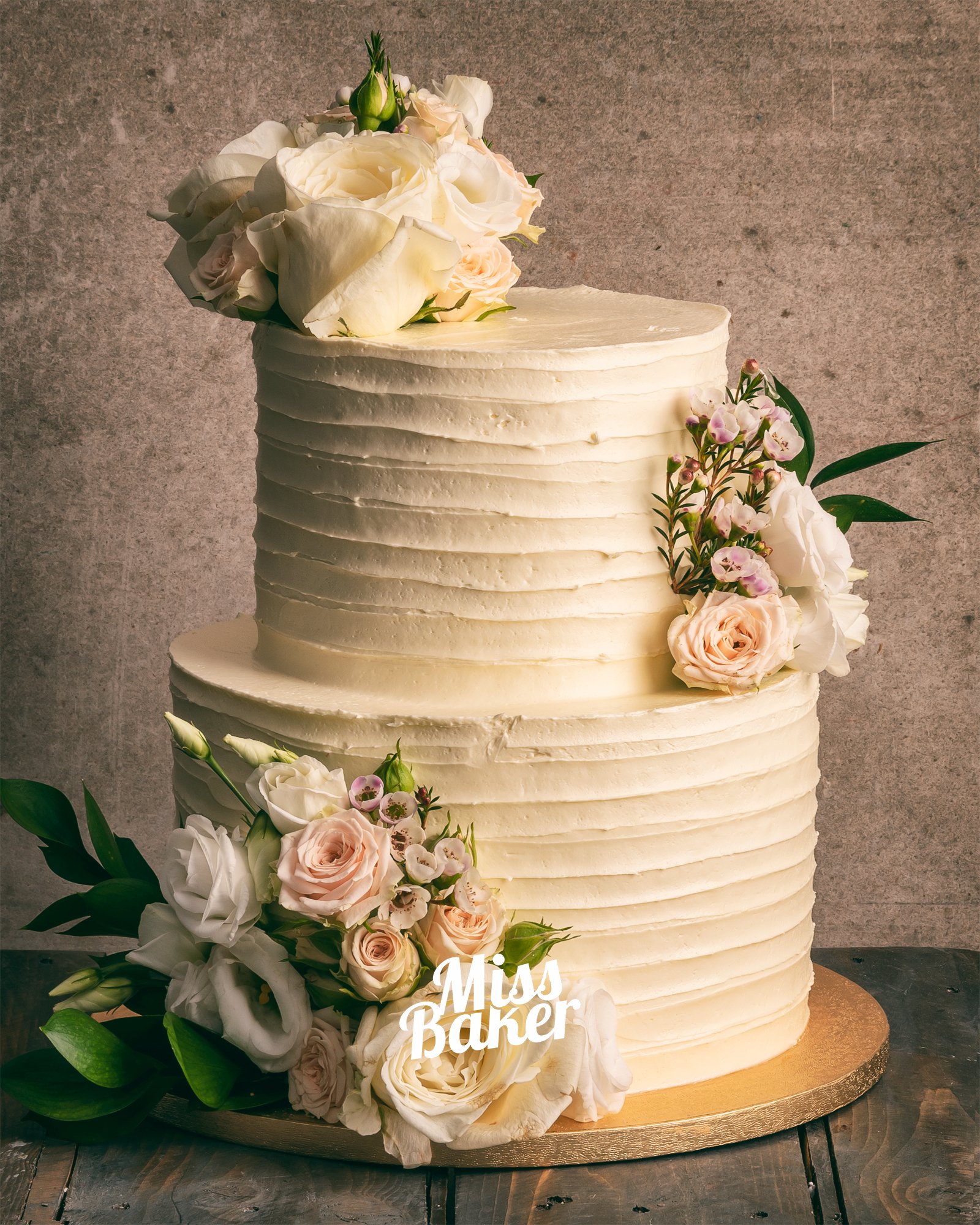 Torturi de nuntă de la Miss Baker — aranjament floral lateral, flori naturale ivoire, flori roz pal