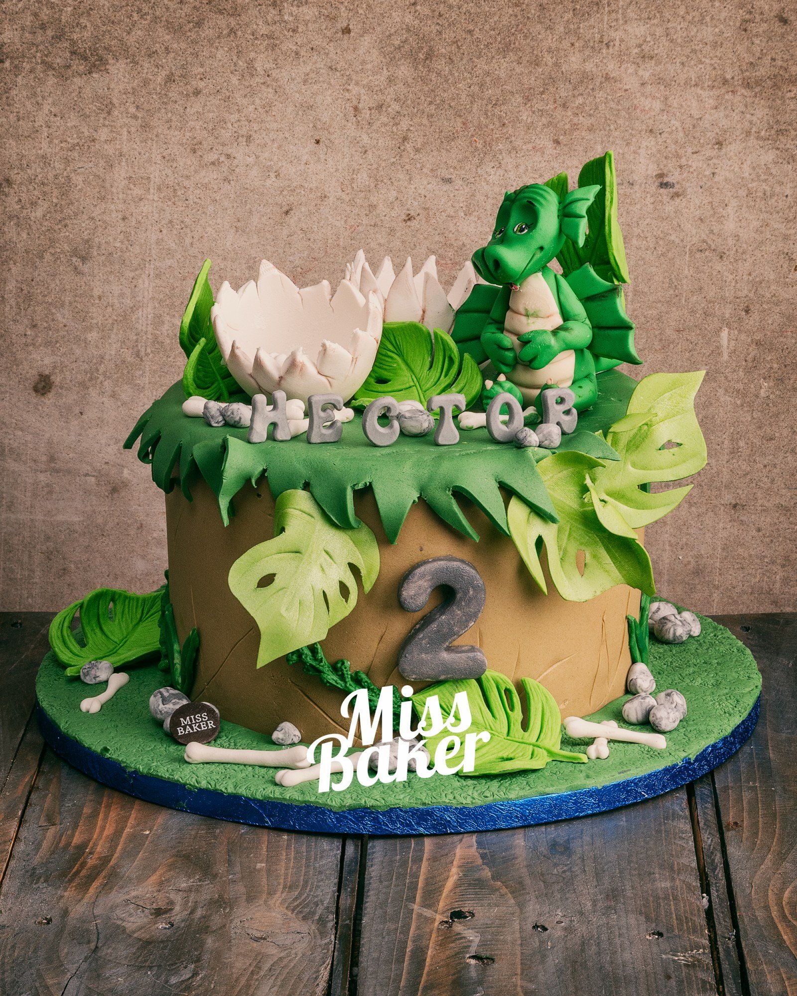 Toturi pentru copii — figurina dragon verde, ou spart alb, frunze tropicale decupate — Miss Baker Constanța