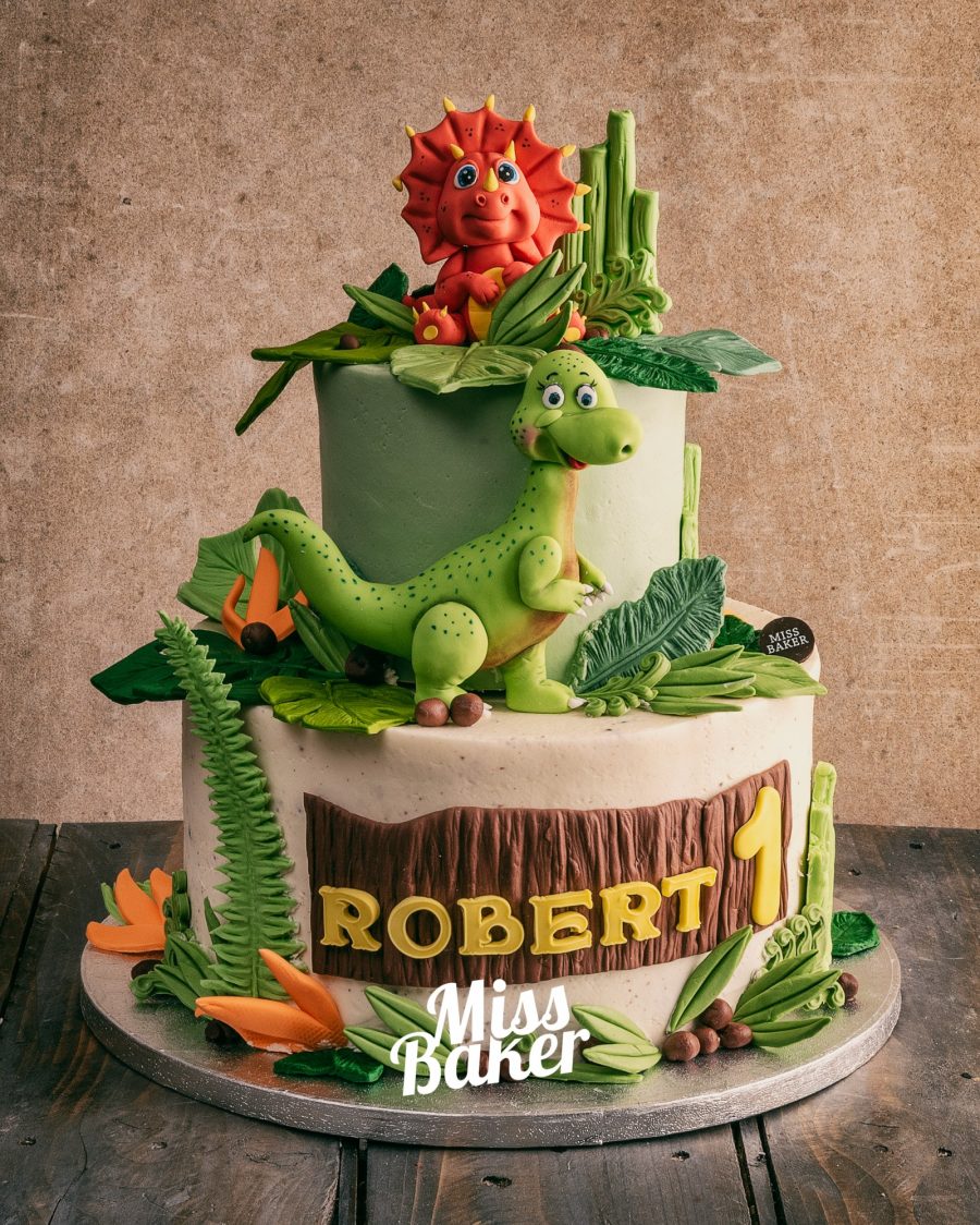 dinozaur verde modelat, triceratops roșu, frunze tropicale — Miss Baker Constanța
